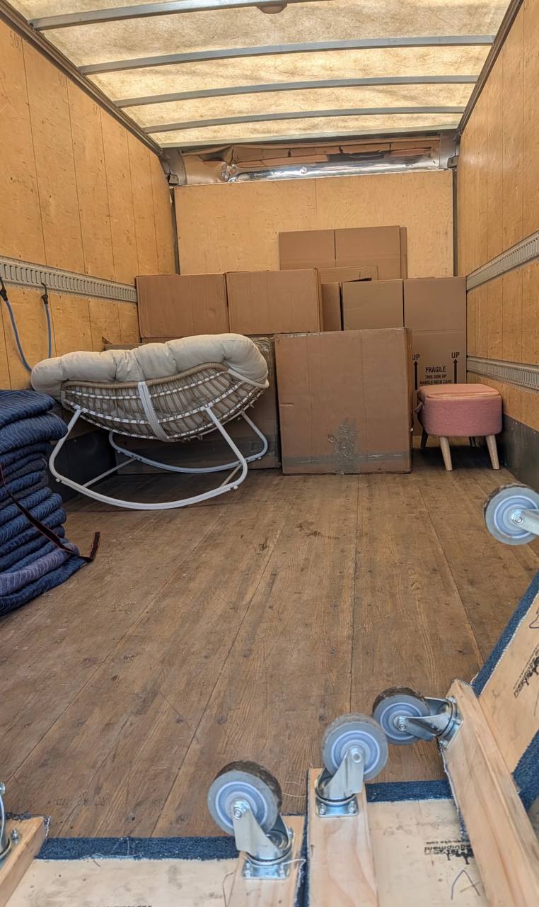 Moving truck with wicker chair and packed boxes